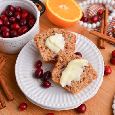 cranberry muffin on plate cut in half with butter