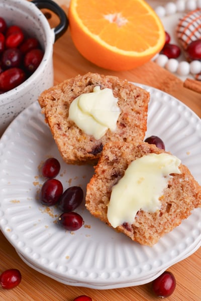 cranberry muffin on plate cut in half with butter