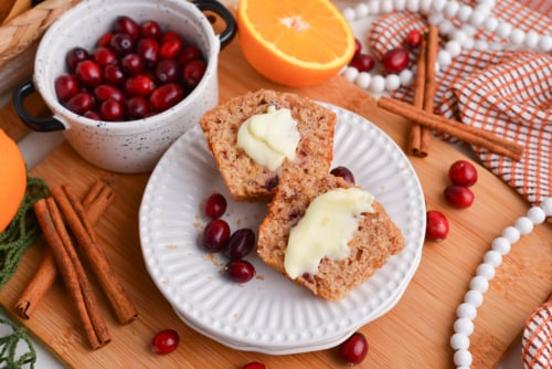 cranberry muffin on plate cut in half with butter
