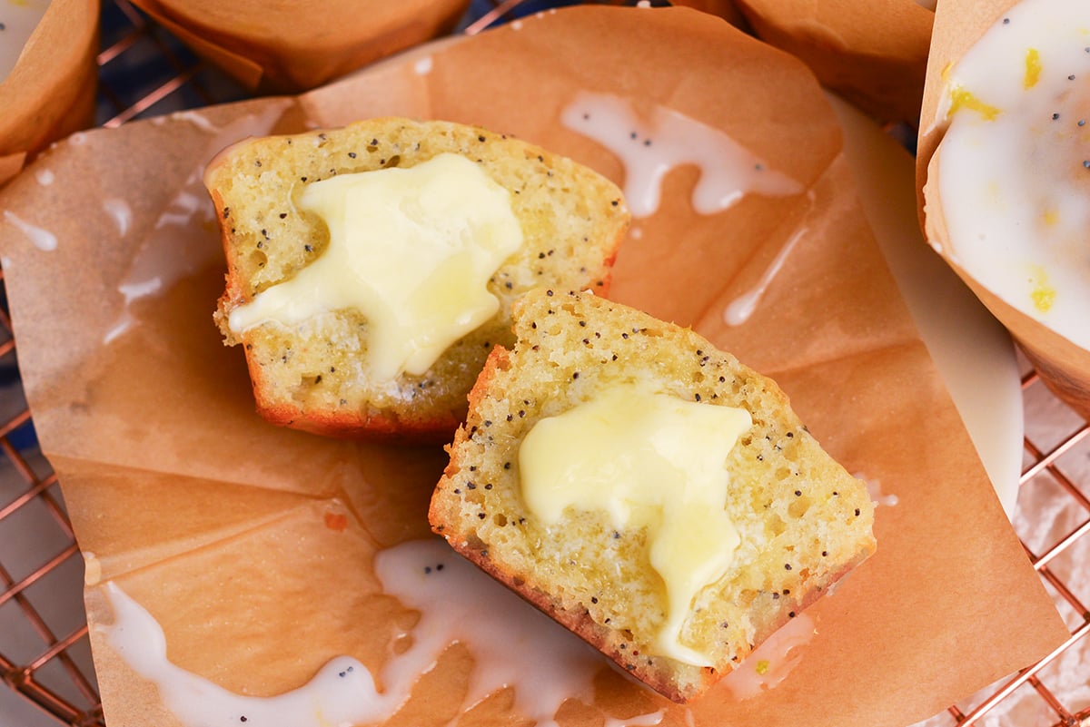 close up of lemon poppy seed muffin cut in half with butter