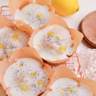 angled shot of moist lemon muffins with glaze on cooling rack