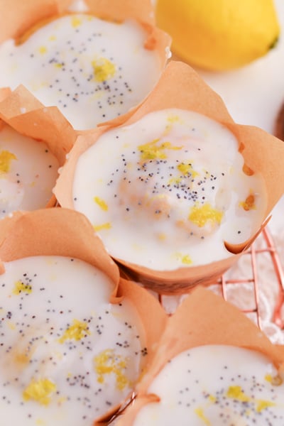 angled shot of moist lemon muffins with glaze on cooling rack