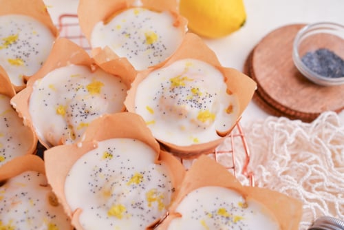angled shot of moist lemon muffins with glaze on cooling rack