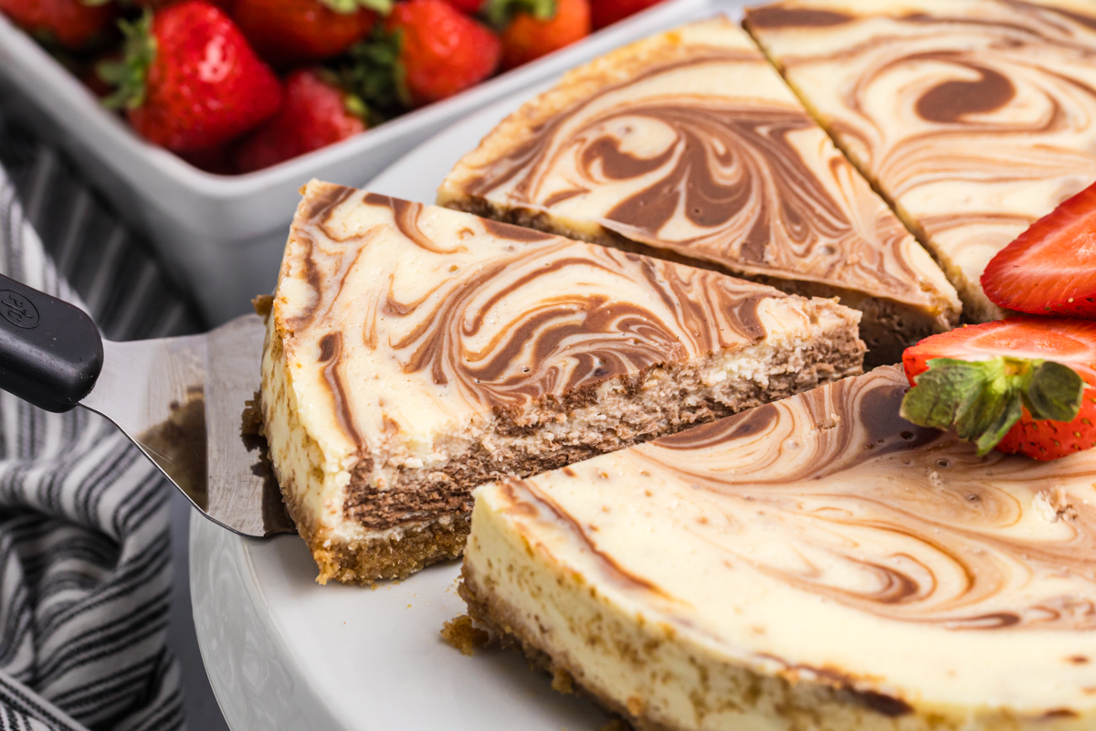 spatula taking slice of new york cheesecake