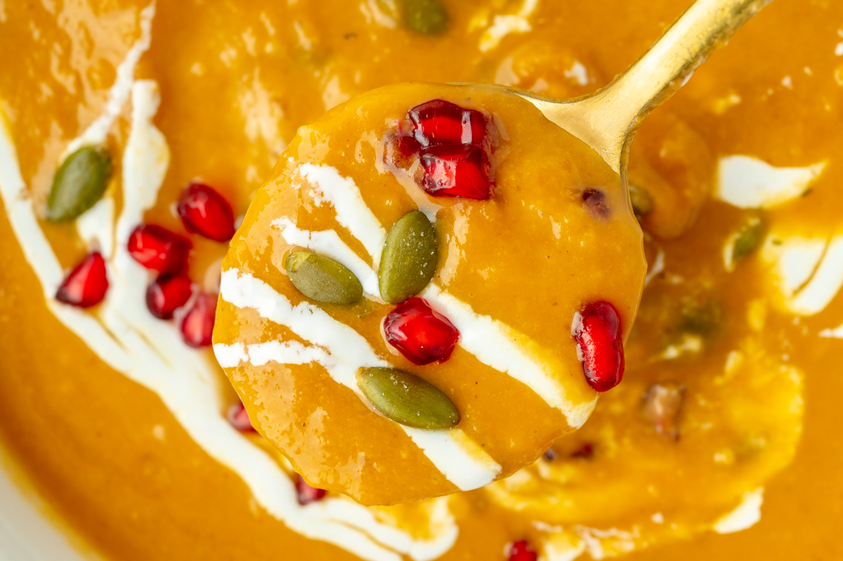 close up of spoon full of creamy pumpkin soup