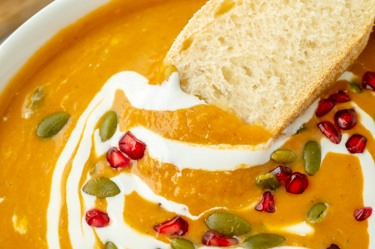 slice of bread dipping into creamy soup
