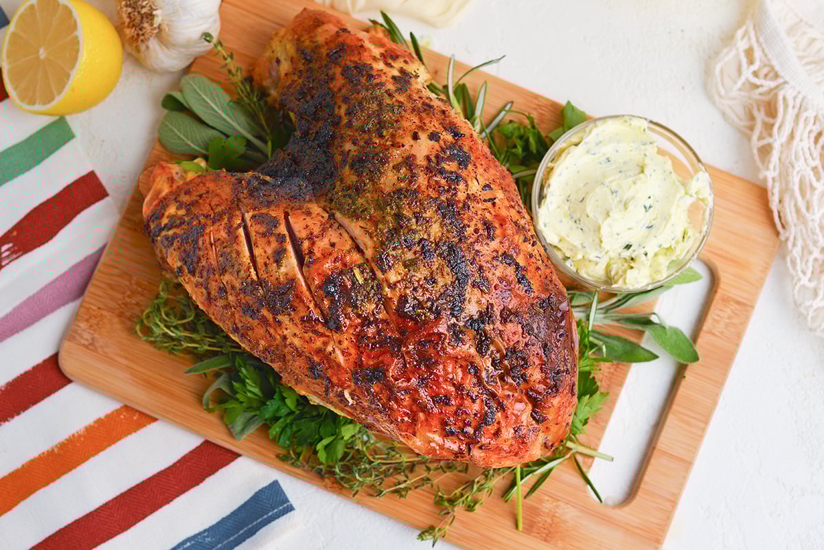 overhead shot of cooked turkey breast on wooden board