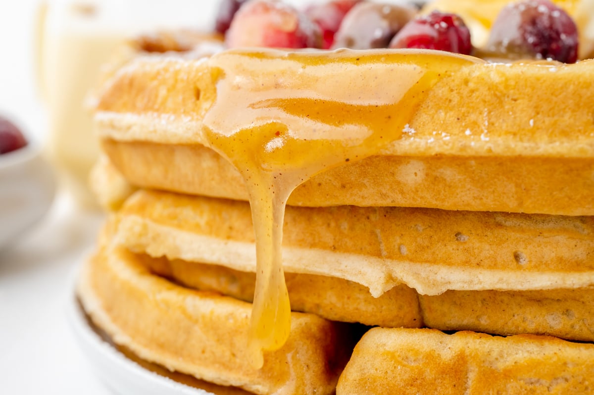close up of syrup dripping from stack of waffles