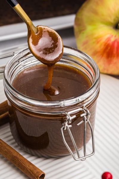 spoon dipping into jar of gingerbread caramel sauce