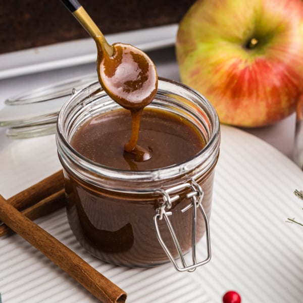 spoon dipping into jar of gingerbread caramel sauce