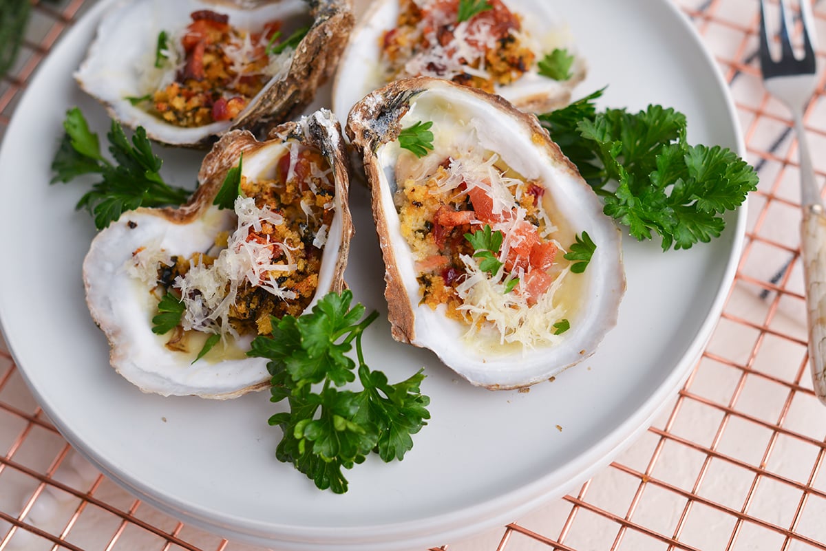 angled shot of cooked oysters on plate with parsley