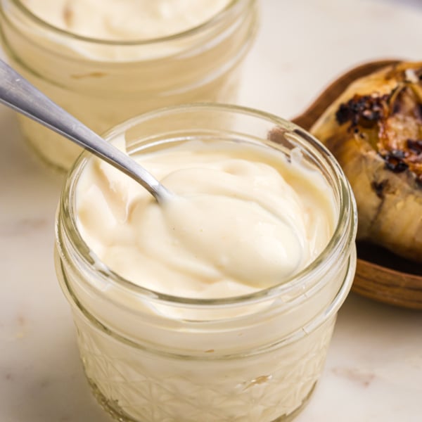 close up of spoon in jar of roasted garlic aioli