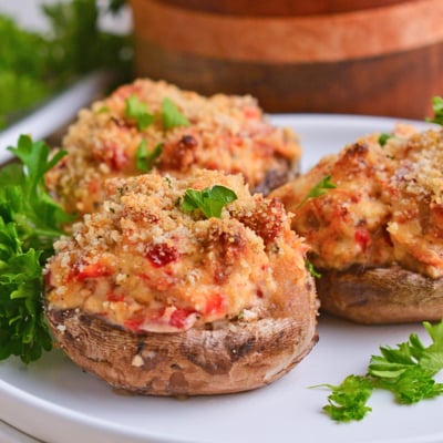 close up shot of three stuffed mushrooms on plate