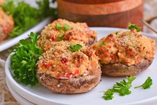 close up shot of three stuffed mushrooms on plate