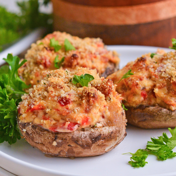 close up shot of three stuffed mushrooms on plate