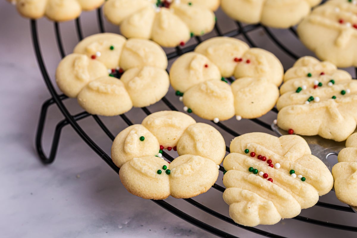 close up angled shot of spritz cookies on cooling rack