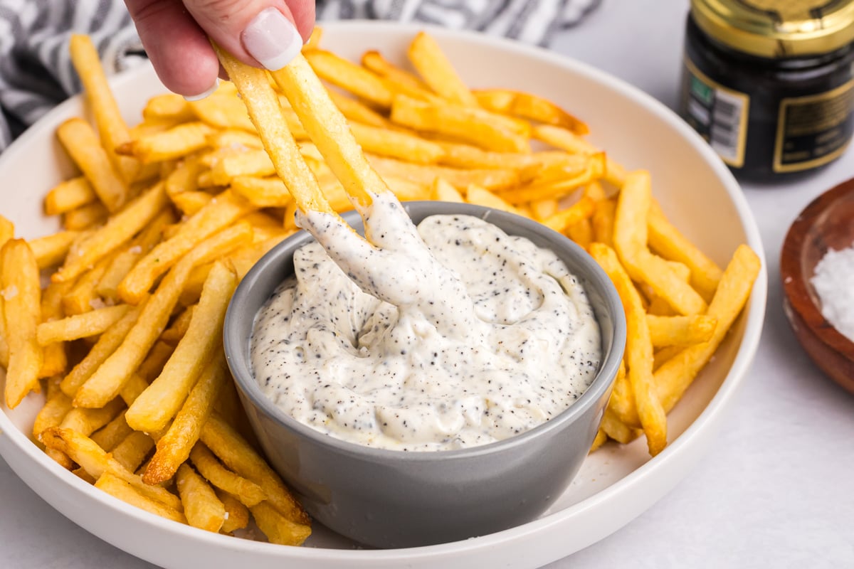 fries dipping into bowl of sauce
