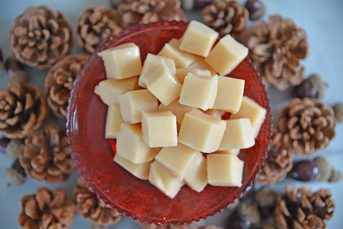 Overhead of vanilla fudge squares on a red serving platter