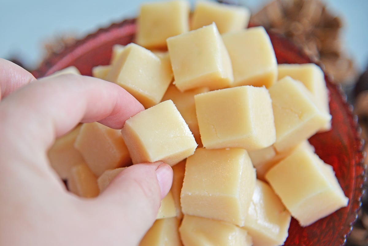 Hand reaching in to grab vanilla fudge square