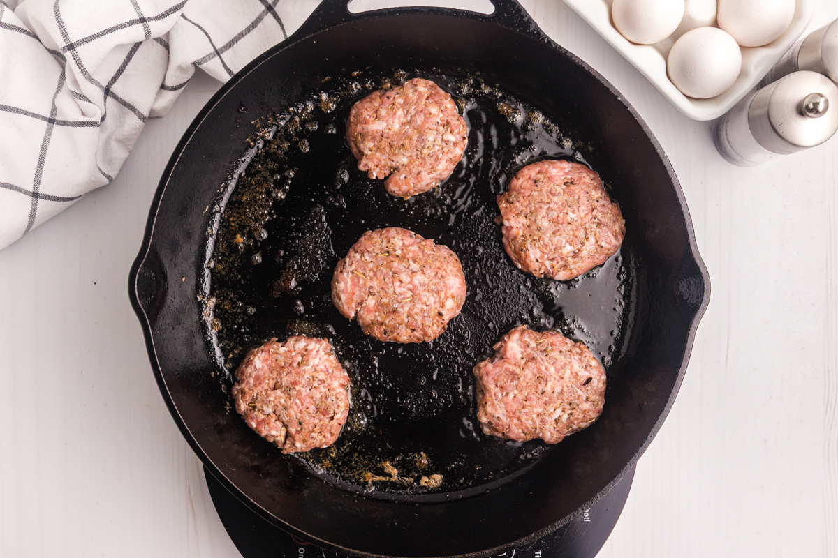 breakfast sausage patties cooking in skillet
