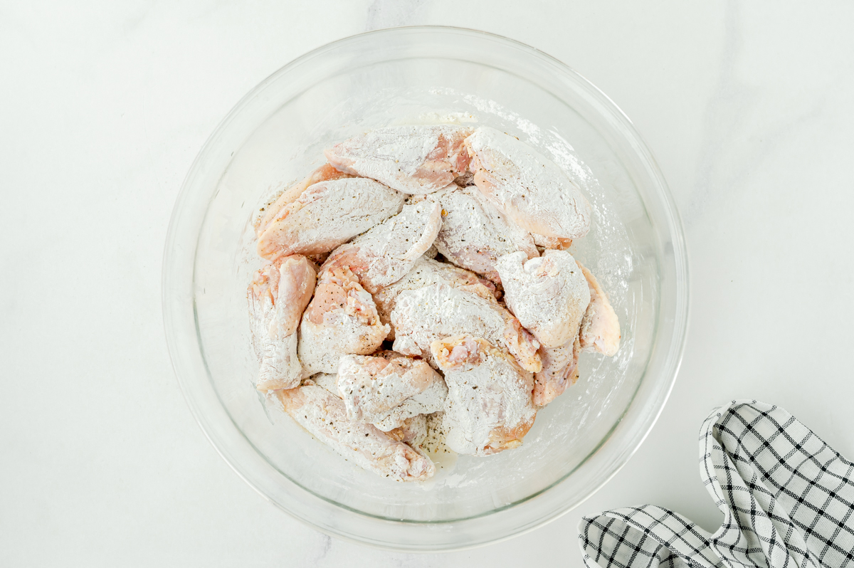 raw wings in bowl of seasoning
