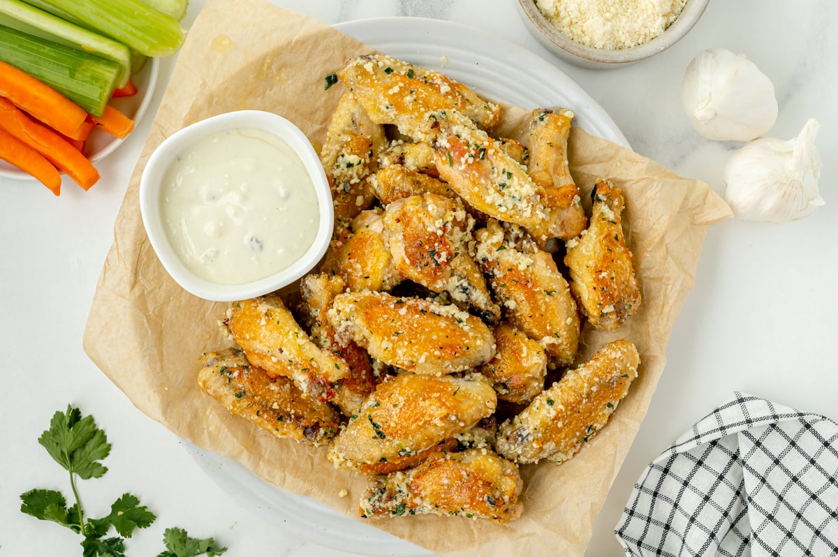 overhead shot of plate of garlic parmesan chicken wings with bowl of ranch