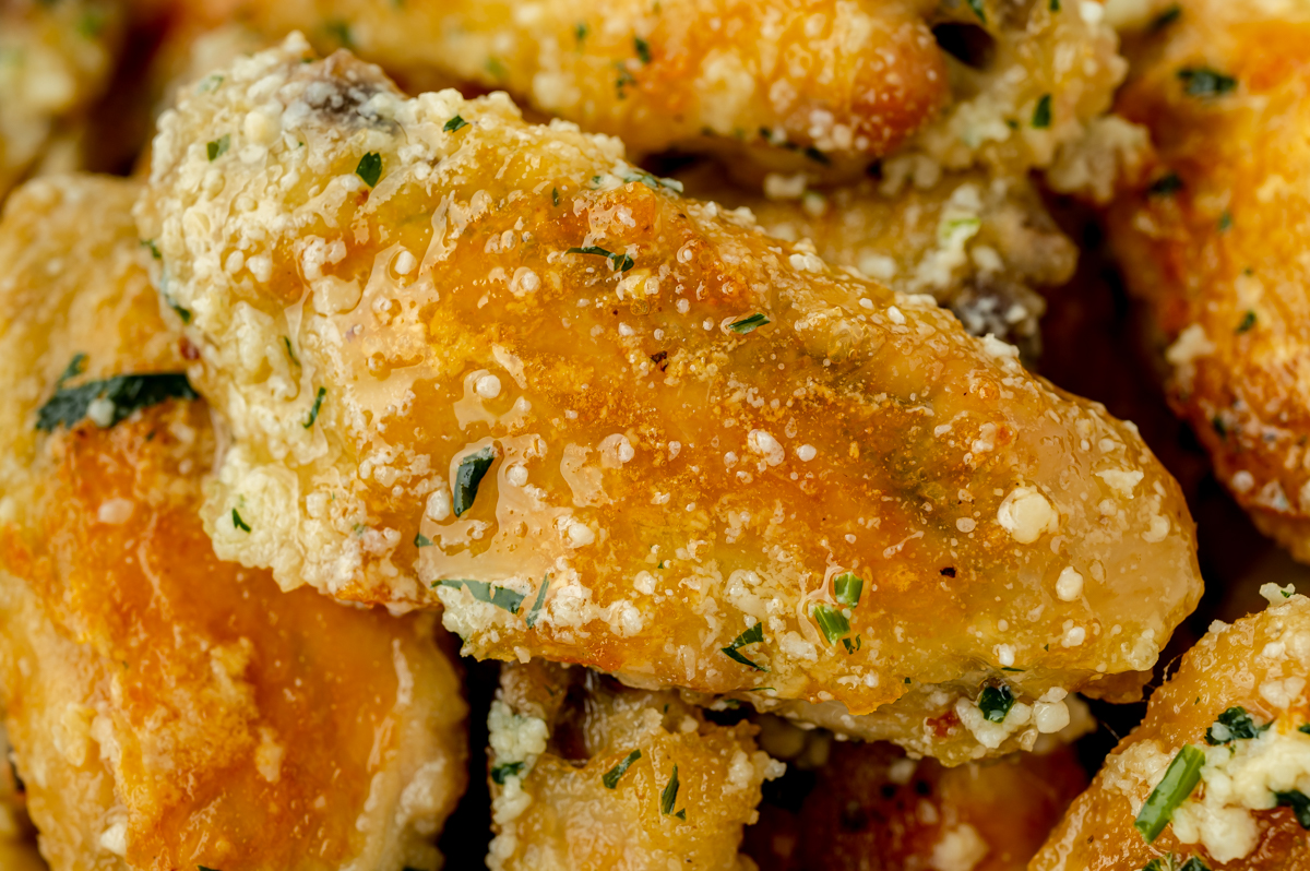 close up shot of chicken wing coated in garlic parm sauce