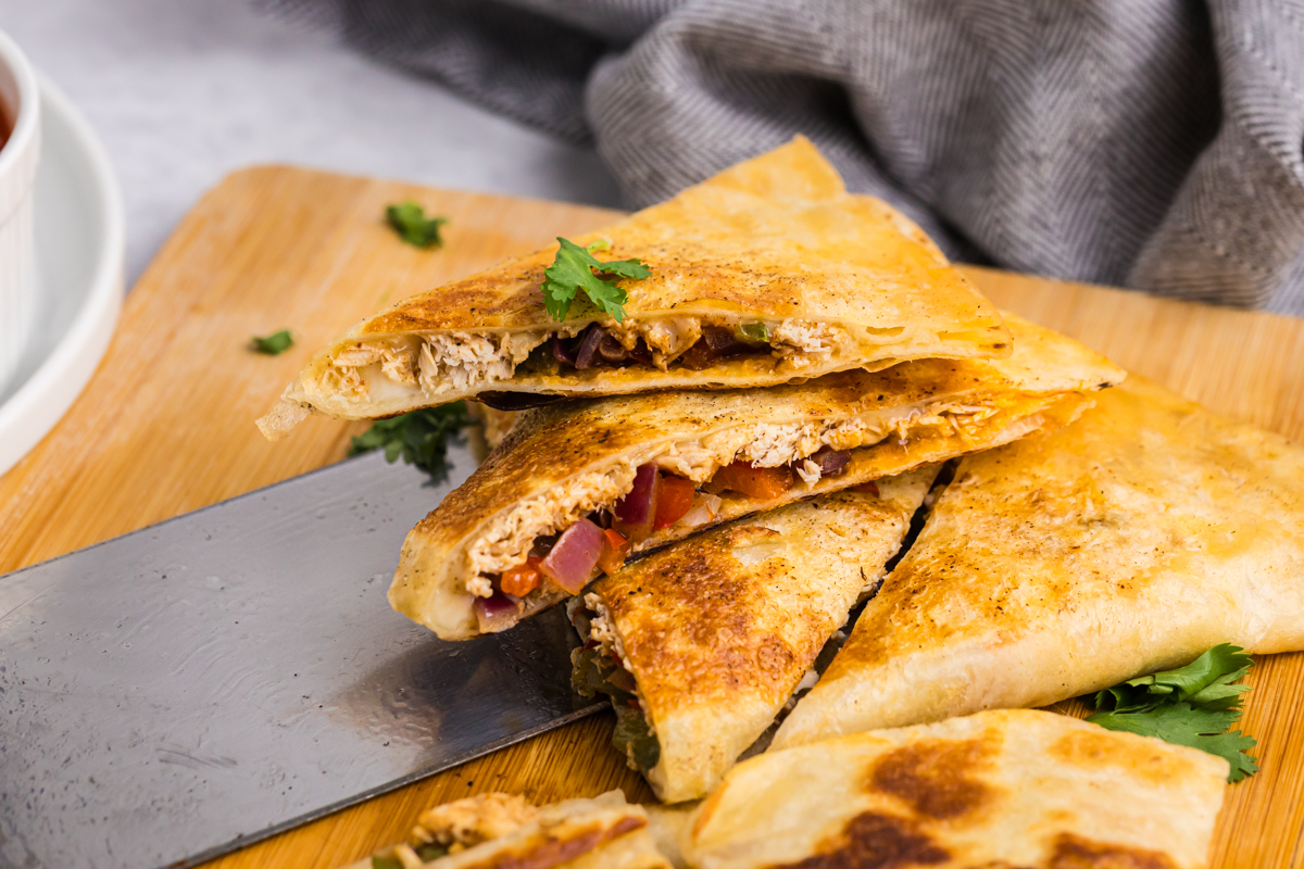 angled shot of chicken quesadilla triangles on spatula