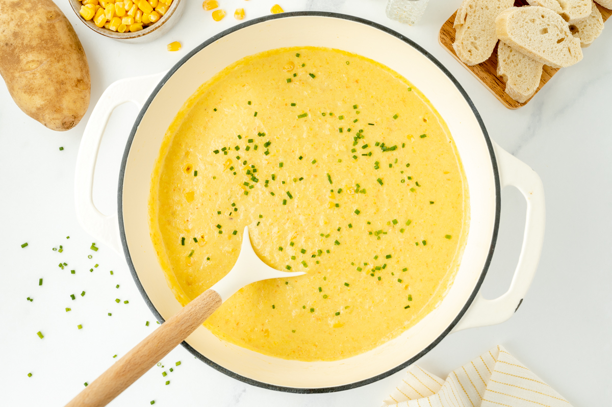 overhead shot of ladle in pot of potato corn chowder