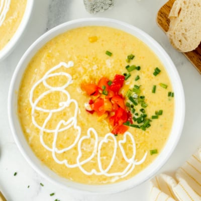 overhead shot of sour cream drizzled in bowl of corn chowder
