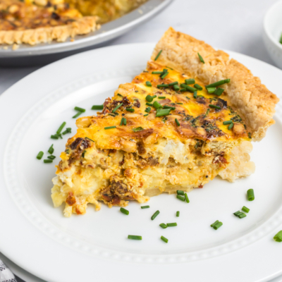 angled shot of slice of goat cheese quiche on plate