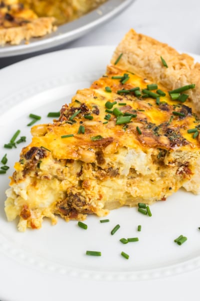 angled shot of slice of goat cheese quiche on plate