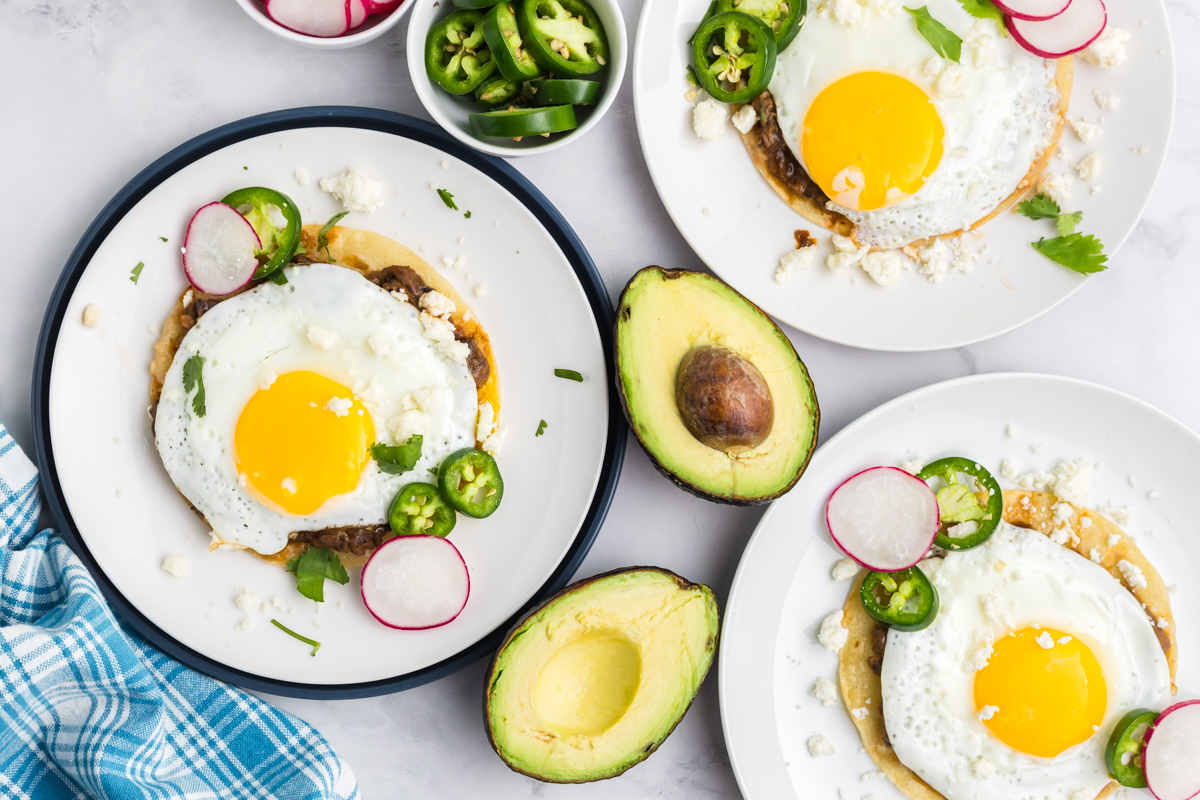 overhead shot of three plates of huevos rancheros