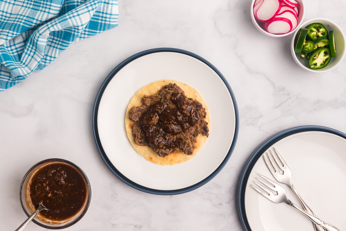 overhead shot of beans on a corn tortilla