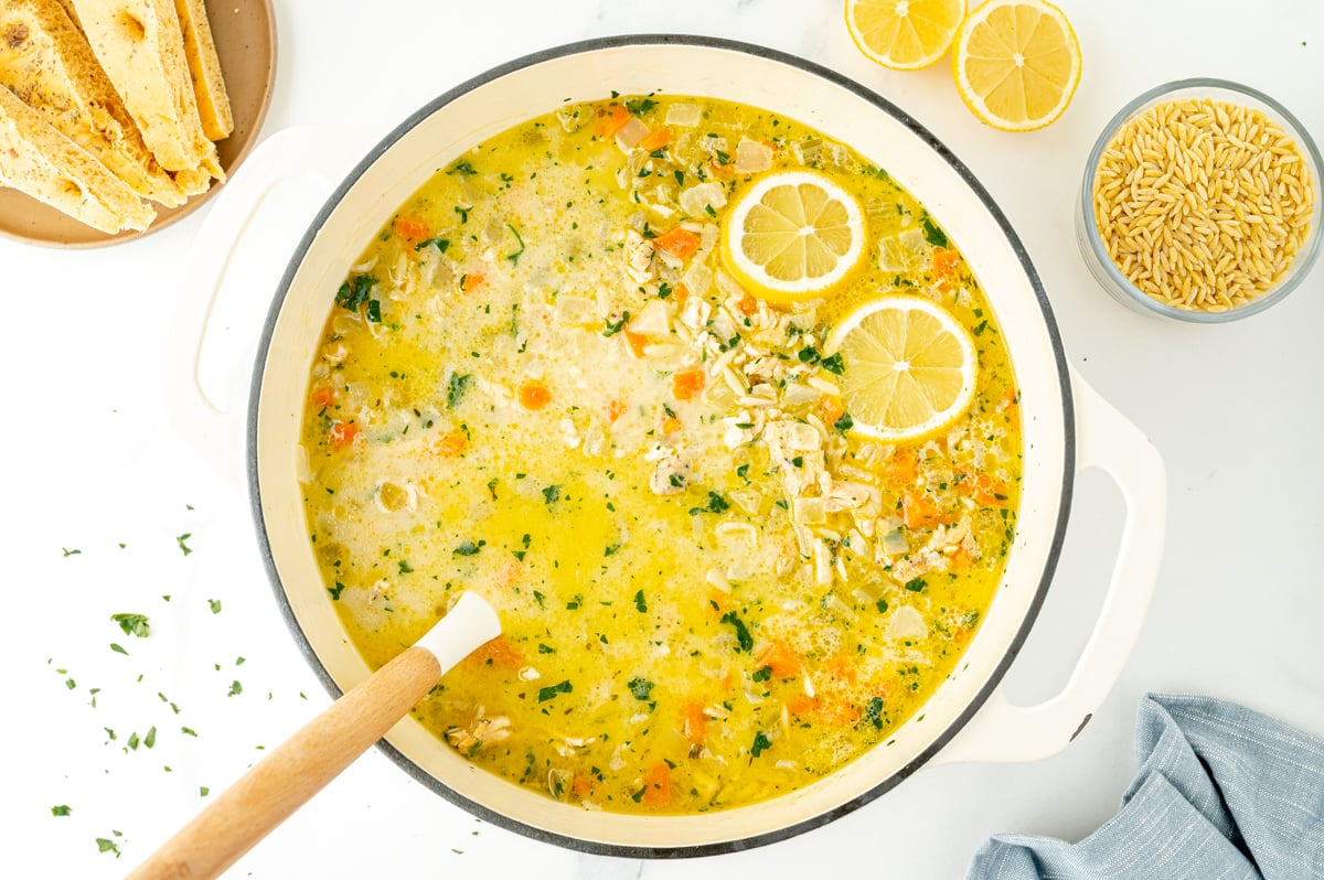 overhead shot of ladle in pot of lemon chicken orzo soup