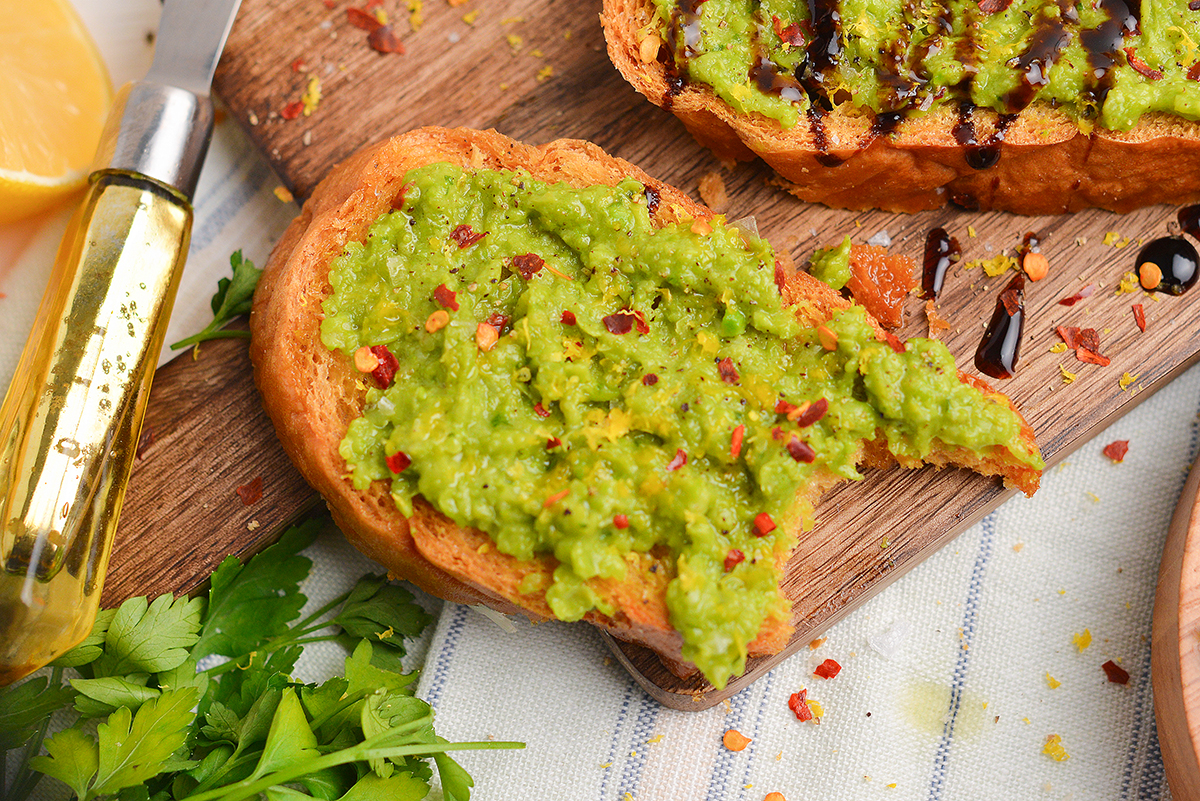 close up of bite taken out of pea crostini