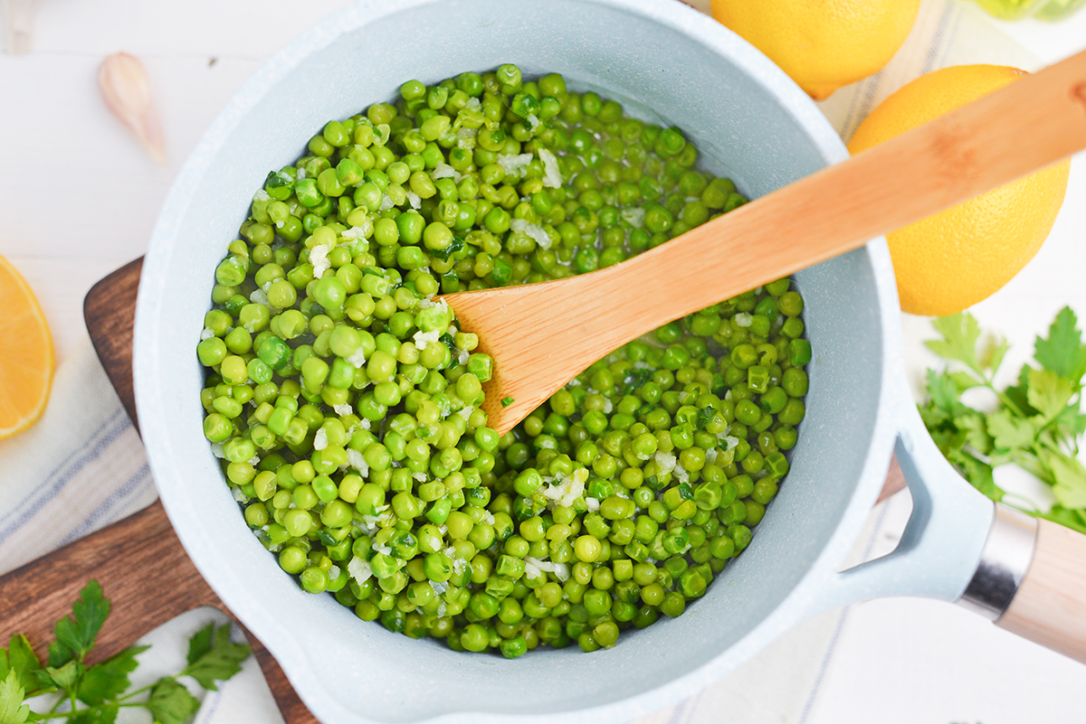 peas in saucepan with wooden spoon