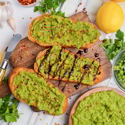 overhead shot of pea mash crostini on board