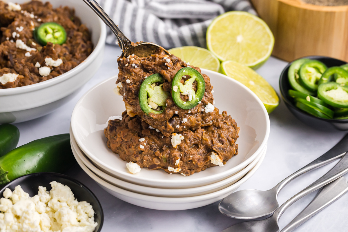 spoon adding black beans to plate