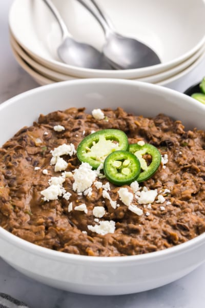 angled shot of bowl of refried black beans