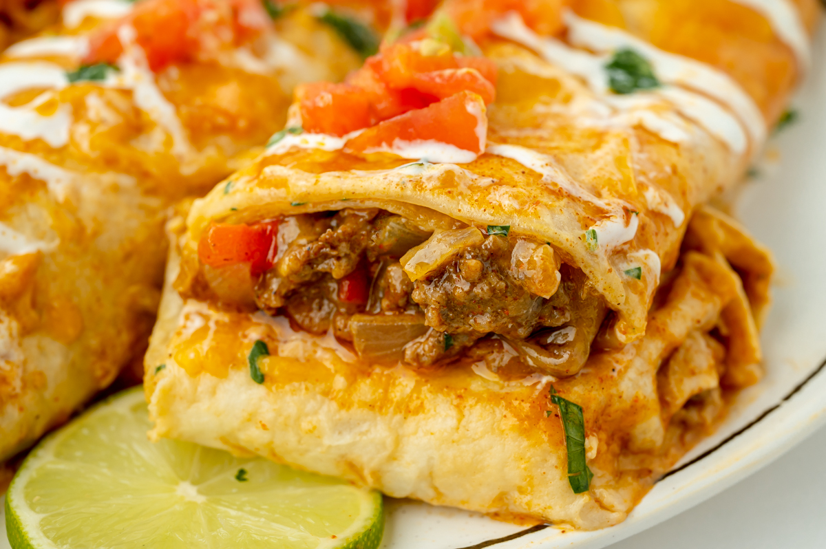angled shot of smothered beef burrito cut in half