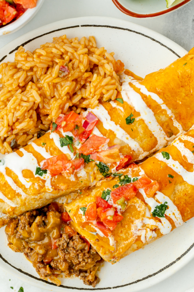overhead shot of smothered beef burritos on plate with rice