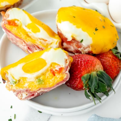 overhead shot of western egg muffin cut in half on plate with strawberries
