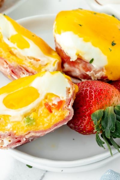 overhead shot of western egg muffin cut in half on plate with strawberries