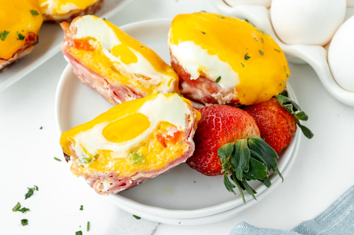 overhead shot of western egg muffin cut in half on plate with strawberries