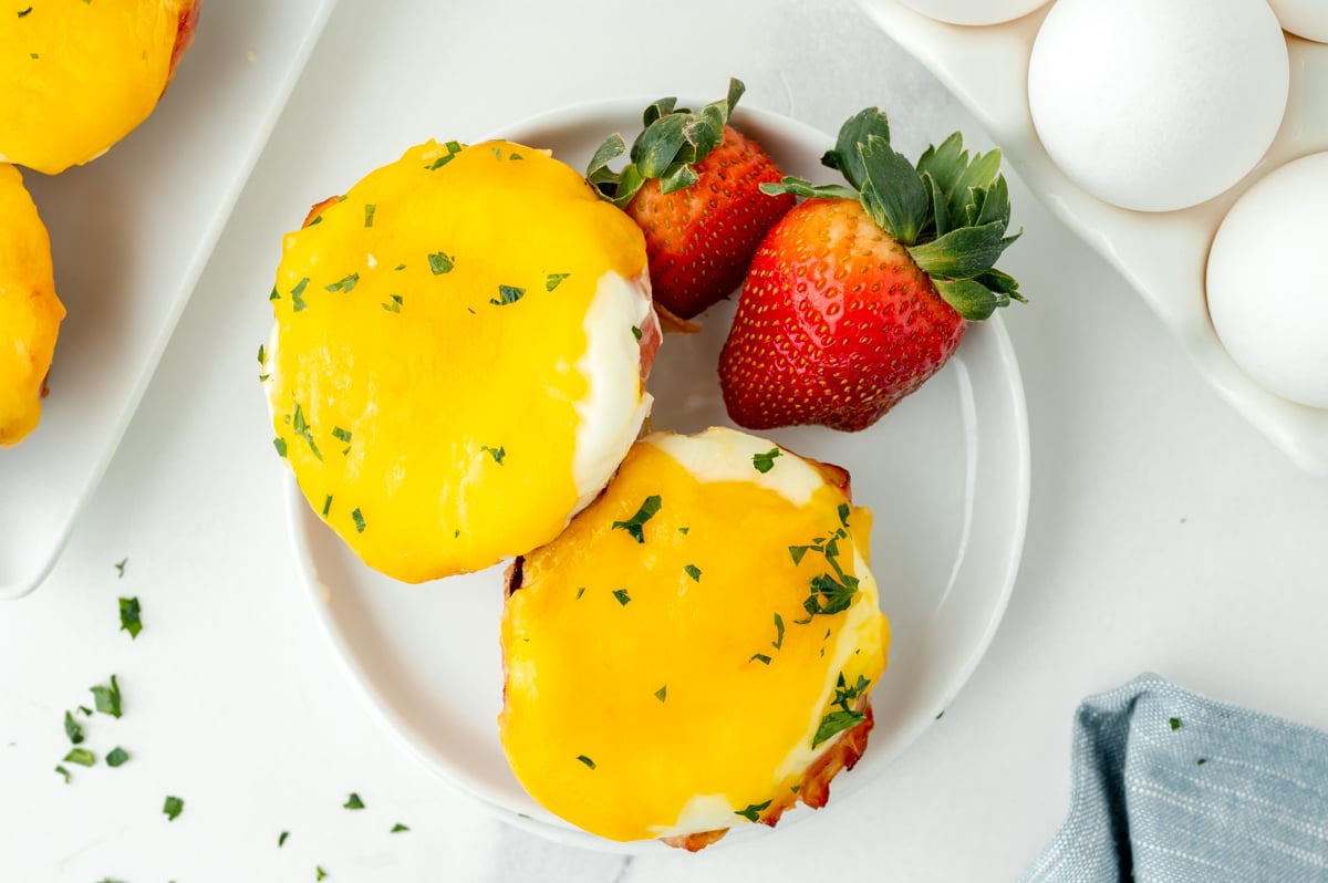 overhead shot of cheesy egg cups on plate with strawberries