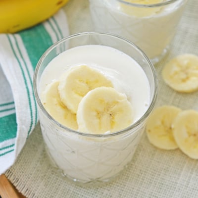 angled overhead of banana smoothie in a glass