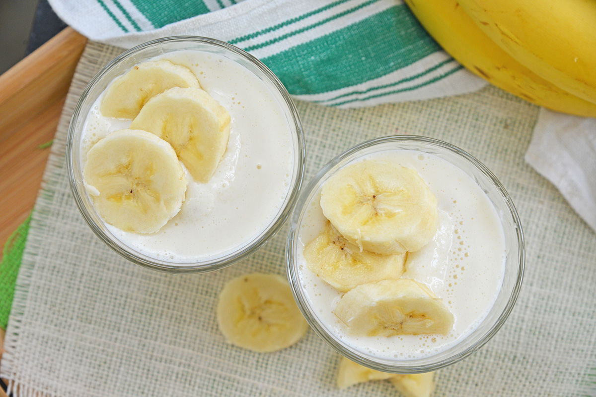 overhead shot of two banana smoothies in cups