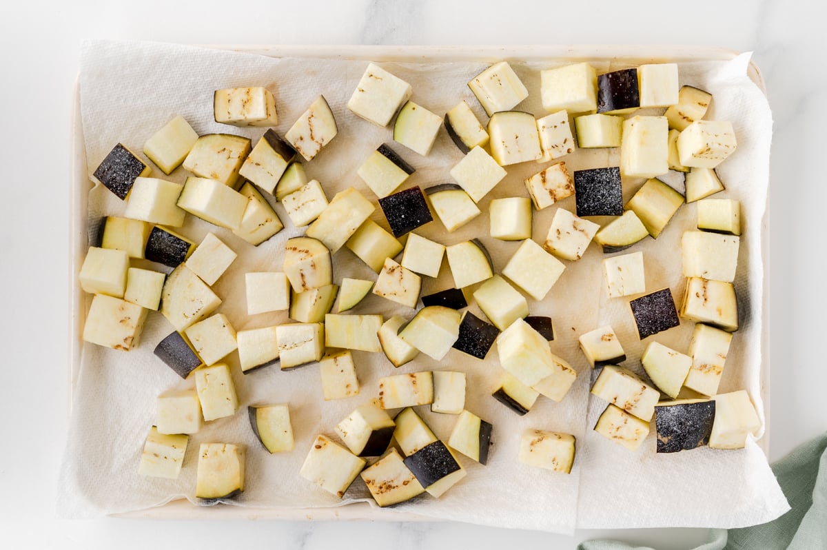 overhead shot of cubed eggplant of baking sheet