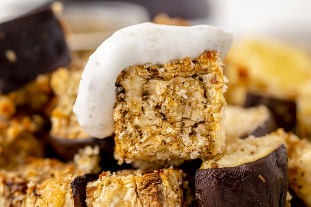 close up of eggplant bite dipped in sauce